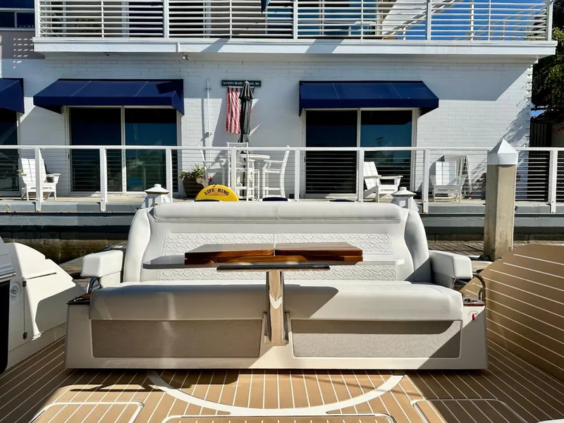 Slide: The Image of 2025 Tiara Yachts 48 LE, luxury seating area with table, docked by waterfront home. - 14