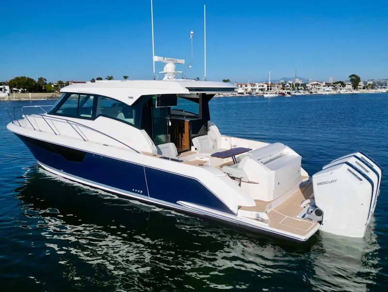 Slide: The Image of 2025 Tiara Yachts 48 LE luxury boat on calm water, showcasing sleek design and powerful engines. - 2