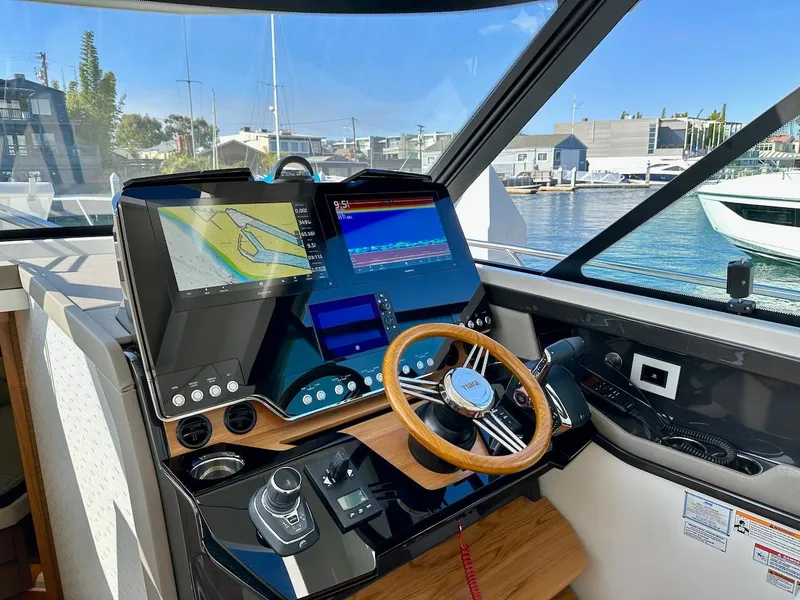 Slide: The Image of Helm of 2025 Tiara Yachts 48 LE with advanced navigation displays and controls. - 25