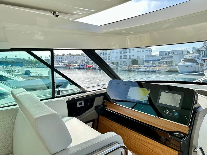 Slide: The Image of Interior view of 2025 Tiara Yachts 48 LE, featuring modern helm and waterfront backdrop. - 29