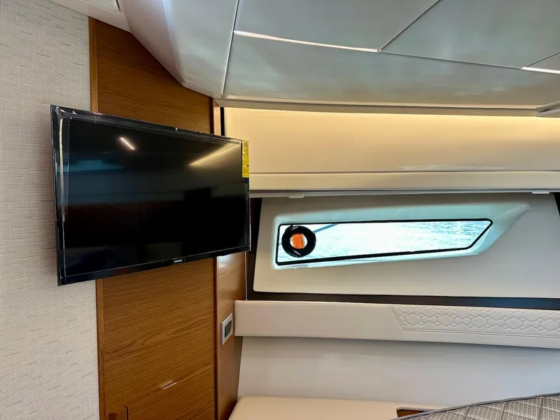 Slide: The Image of Interior of 2025 Tiara Yachts 48 LE, featuring a mounted TV and sleek window design. - 32