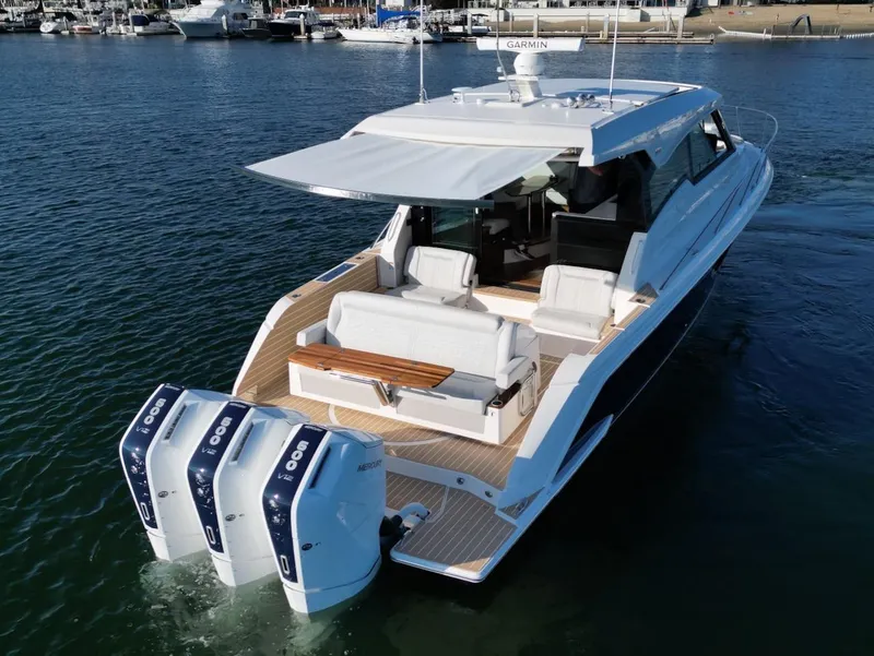 Slide: The Image of 2025 Tiara Yachts 48 LE with triple outboard engines on the water. - 4