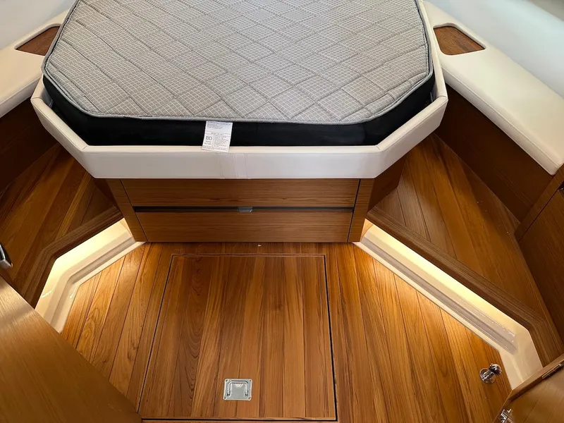 Slide: The Image of 2025 Tiara Yachts 48 LE interior with wooden flooring and cushioned bed. - 47