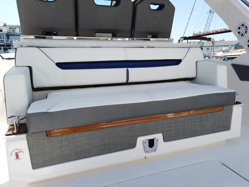 Slide: The Image of 2024 Tiara Sport 34LS boat seating area with cushioned bench and modern design. - 9