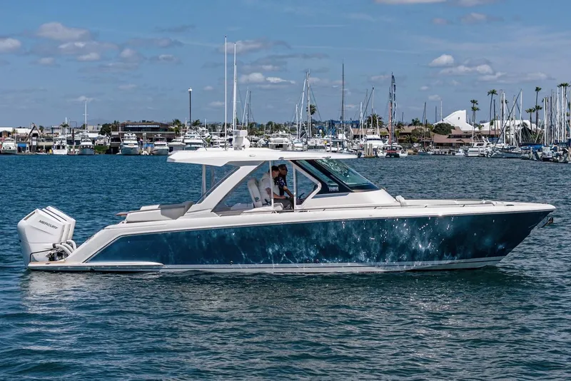 Slide: The Image of 2024 Tiara Yachts 38 LS cruising on a sunny day, marina in the background. - 10