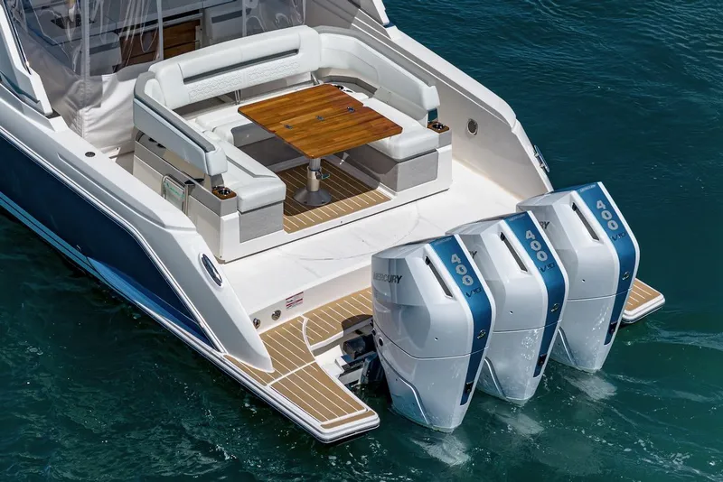 Slide: The Image of 2024 Tiara Yachts 38 LS with triple outboard engines and elegant seating area. - 24