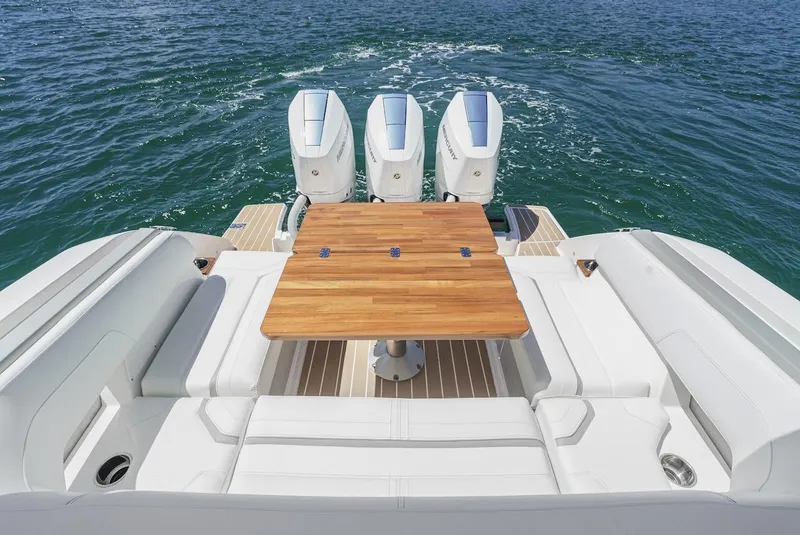 Slide: The Image of 2024 Tiara Yachts 38 LS with triple engines and elegant seating on open water. - 26