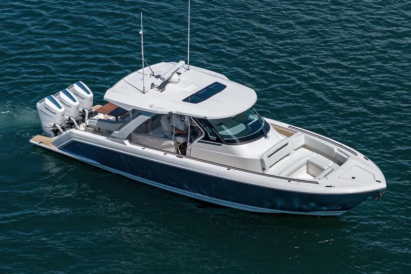 Slide: The Image of 2024 Tiara Yachts 38 LS luxury boat on open water, featuring triple outboard engines. - 3