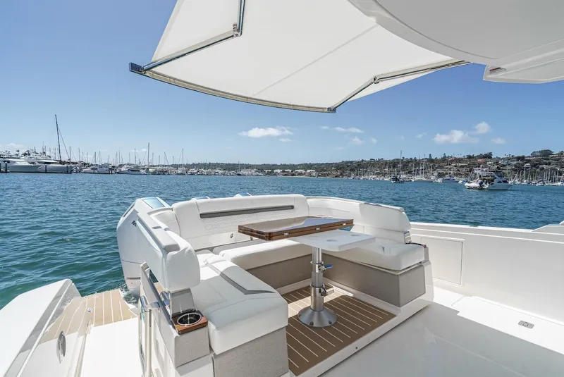 Slide: The Image of 2024 Tiara Yachts 38 LS with elegant seating, docked in a scenic marina. - 30
