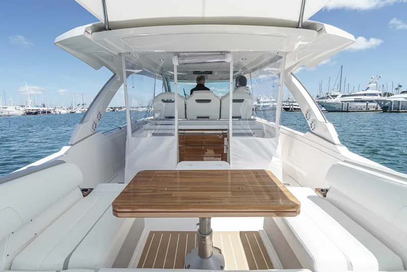 Slide: The Image of 2024 Tiara Yachts 38 LS interior with seating and table, docked in a marina. - 33