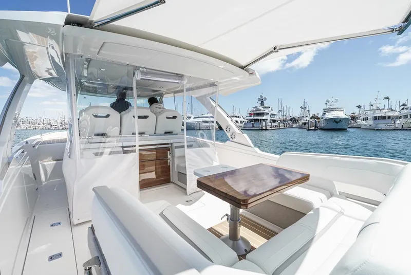 Slide: The Image of 2024 Tiara Yachts 38 LS luxury boat interior with seating and table, docked at marina. - 34