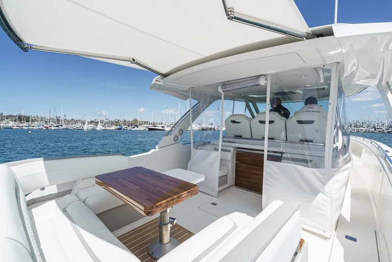 Slide: The Image of 2024 Tiara Yachts 38 LS interior with seating and table, overlooking marina. - 35