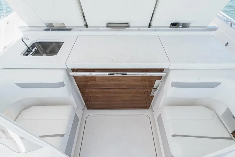 Slide: The Image of 2024 Tiara Yachts 38 LS interior with sleek kitchenette, featuring sink and storage. - 36