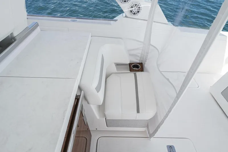 Slide: The Image of 2024 Tiara Yachts 38 LS interior with white seating and cup holder, overlooking water. - 41