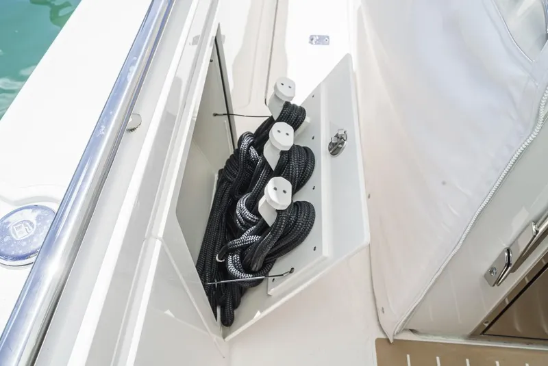 Slide: The Image of 2024 Tiara Yachts 38 LS boat storage compartment with neatly coiled ropes. - 43