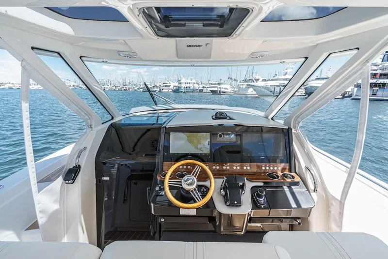 Slide: The Image of 2024 Tiara Yachts 38 LS helm with modern controls and panoramic marina view. - 44