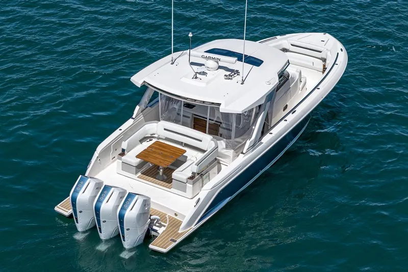 Slide: The Image of 2024 Tiara Yachts 38 LS on water, featuring triple outboard engines and spacious deck. - 5