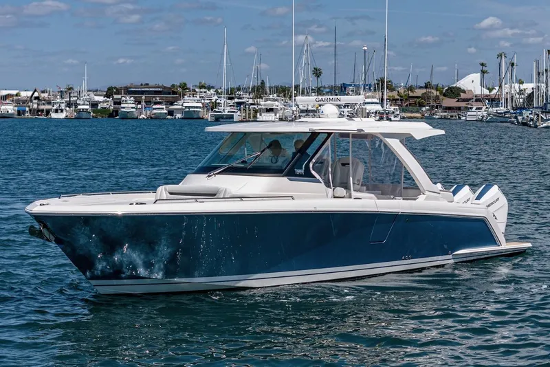 Slide: The Image of 2024 Tiara Yachts 38 LS cruising on a sunny day in a marina. - 6