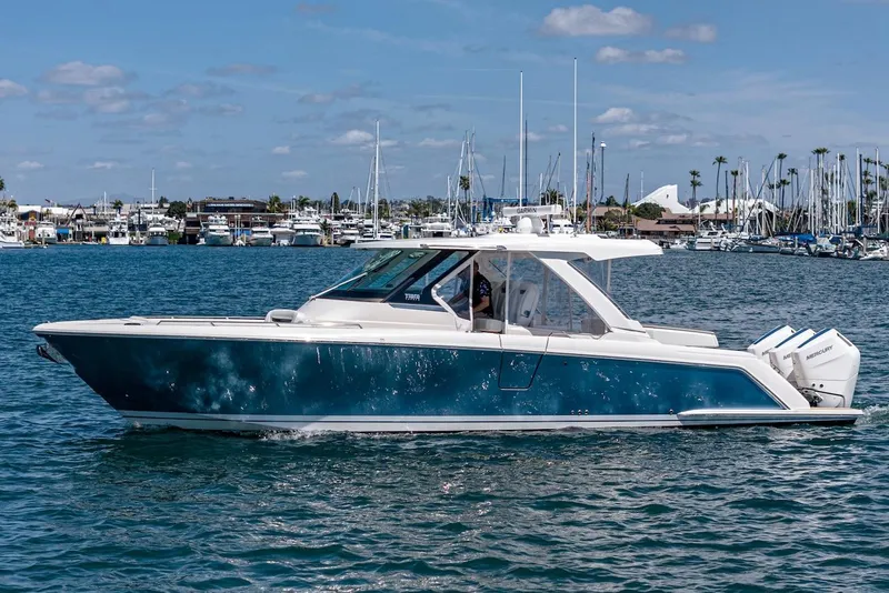 Slide: The Image of 2024 Tiara Yachts 38 LS cruising on a sunny day, with marina in the background. - 8