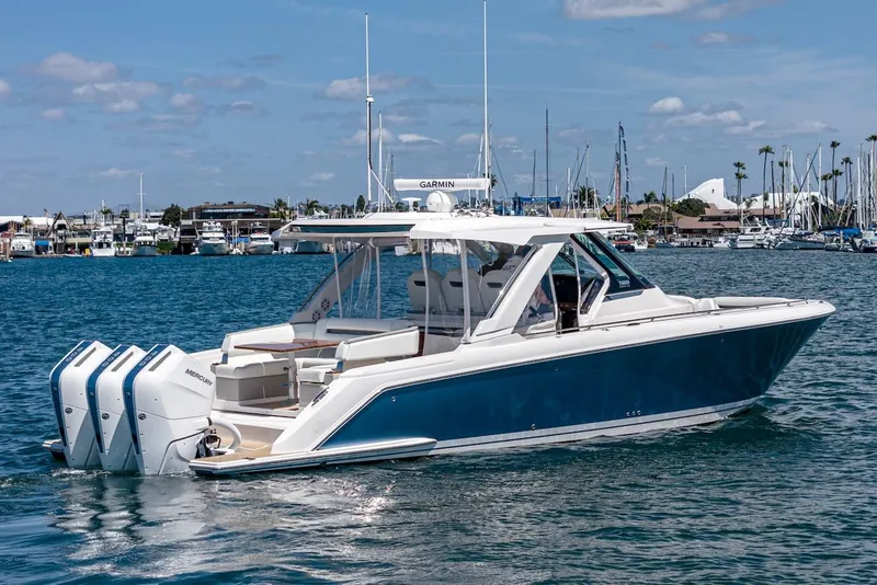 Slide: The Image of 2024 Tiara Yachts 38 LS in marina, featuring triple outboard engines. - 9