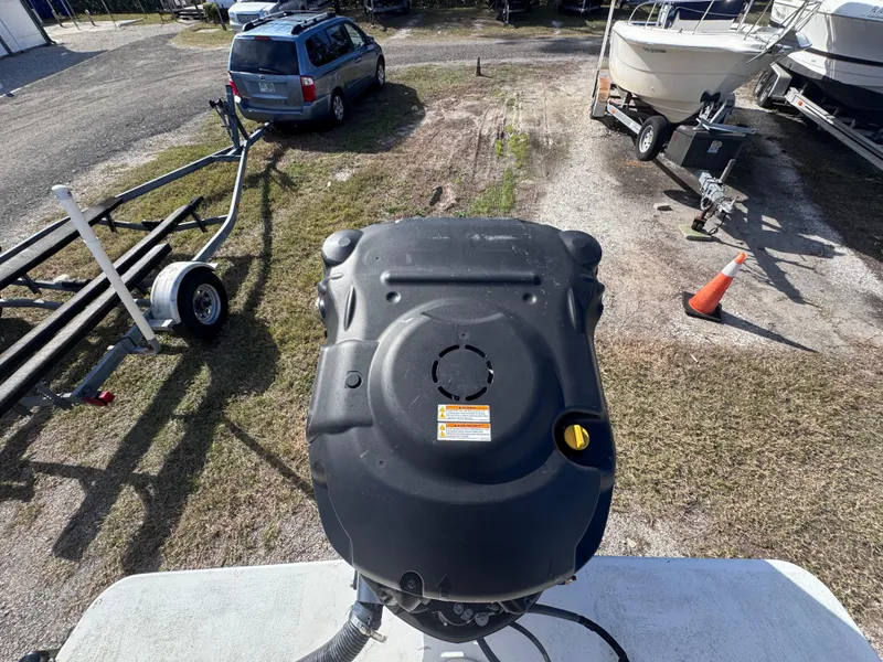Slide: The Image of Outboard motor on a 2005 Parker 2520 Deep Vee Sport Cabin boat, parked near trailers. - 18