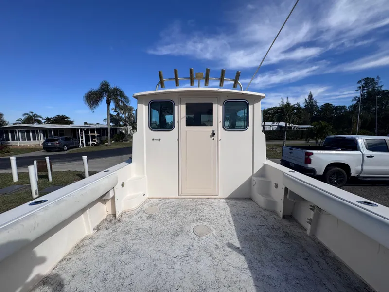 Slide: The Image of 2005 Parker 2520 Deep Vee Sport Cabin boat, docked with clear sky background. - 21