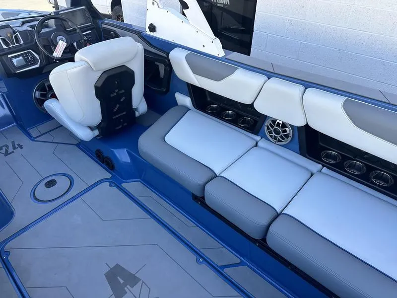Slide: The Image of 2022 Axis A24 boat interior with blue and white seating, steering wheel, and speaker system. - 10