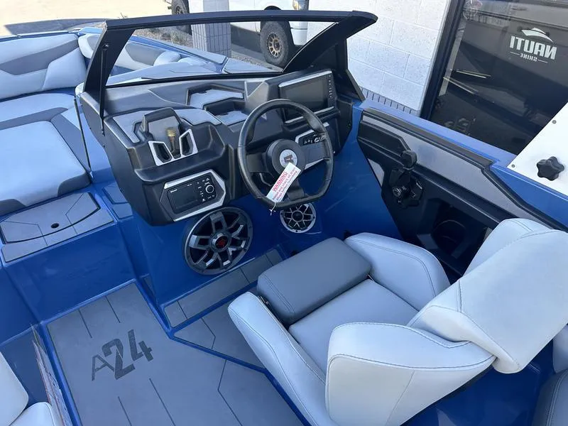 Slide: The Image of 2022 Axis A24 boat interior with modern dashboard, steering wheel, and seating. - 12