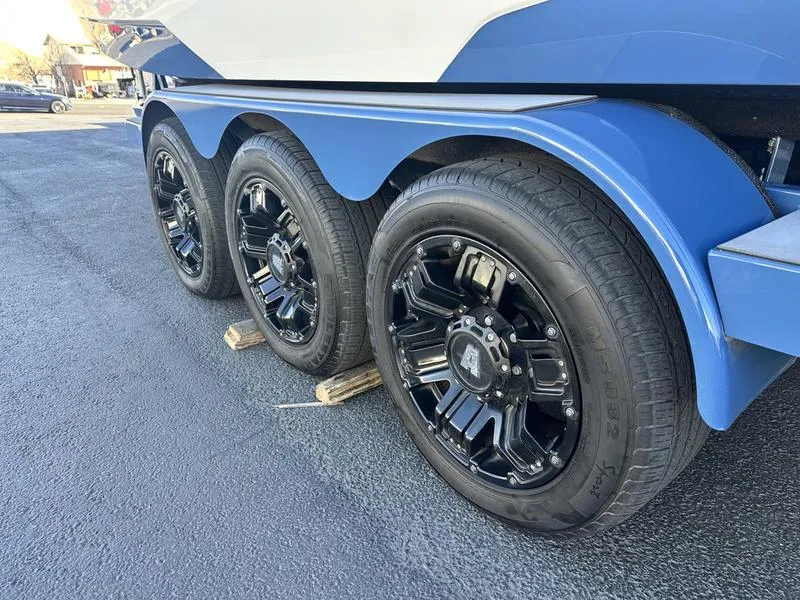 Slide: The Image of 2022 Axis A24 trailer with three black wheels on a paved surface. - 5