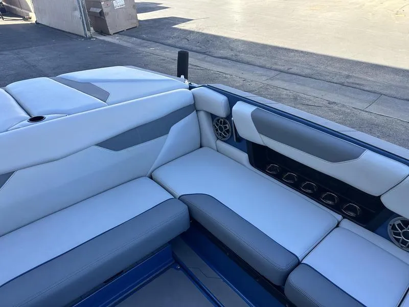 Slide: The Image of 2022 Axis A24 boat interior with gray and white seating and built-in speakers. - 8