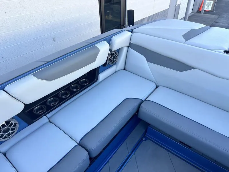 Slide: The Image of 2022 Axis A24 boat interior with blue and gray seating and built-in speakers. - 9