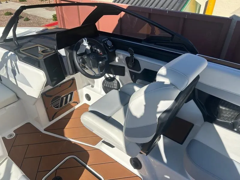 Slide: The Image of 2025 Malibu 23 LSV boat interior with white seating and modern dashboard. - 10