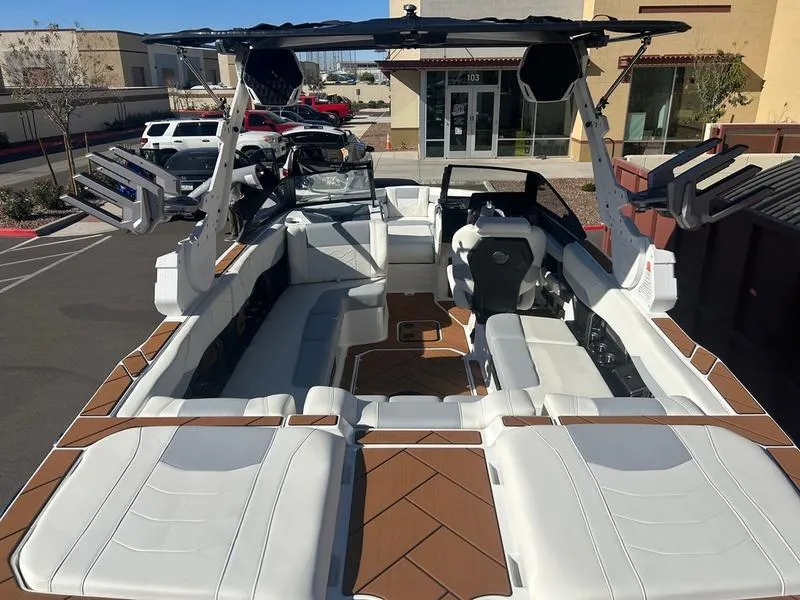 Slide: The Image of 2025 Malibu 23 LSV boat with spacious seating and modern design in a parking lot. - 11