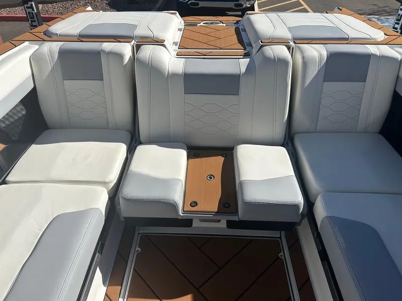 Slide: The Image of 2025 Malibu 23 LSV boat interior with luxurious white seating and wooden accents. - 13