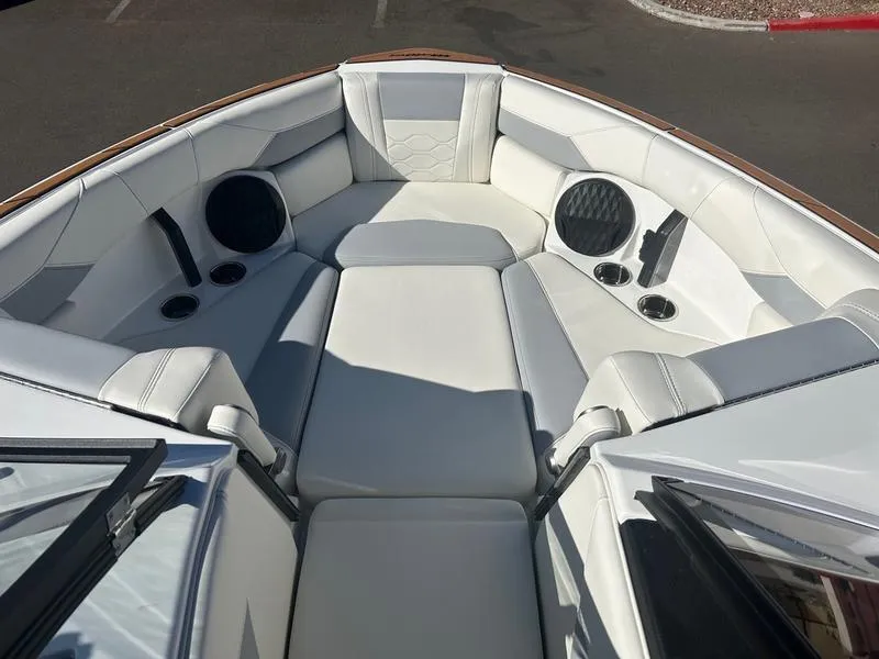 Slide: The Image of 2025 Malibu 23 LSV boat interior with white seating and built-in speakers. - 15