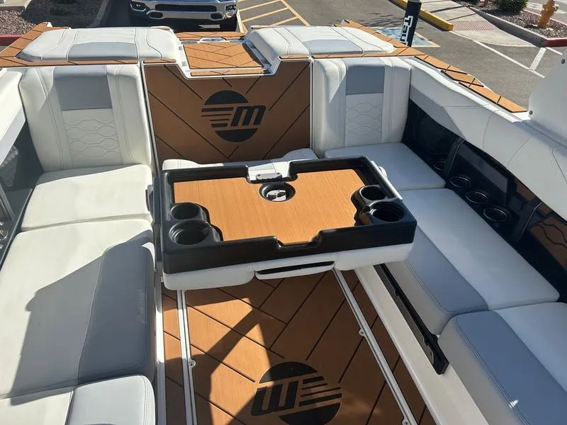 Slide: The Image of 2025 Malibu 23 LSV boat interior with white seating and wooden accents. - 19
