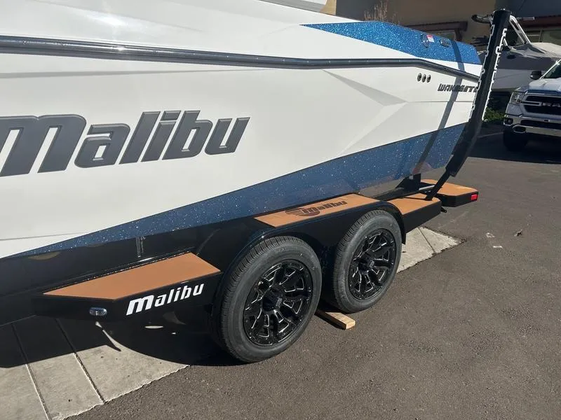 Slide: The Image of 2025 Malibu 23 LSV boat on a trailer, featuring sleek design and branding. - 5