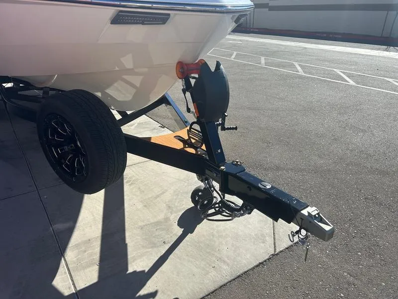 Slide: The Image of Trailer hitch of a 2025 Malibu 23 LSV boat in a parking lot. - 6