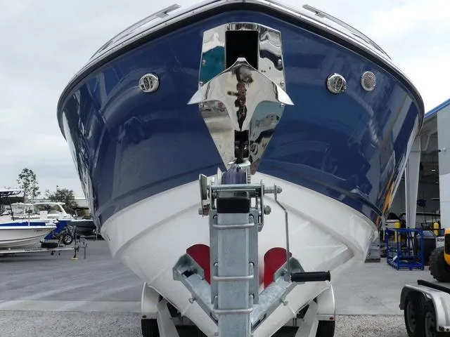 Slide: The Image of 2025 Monterey Elite 30 OB boat, blue and white hull, front view on trailer. - 2