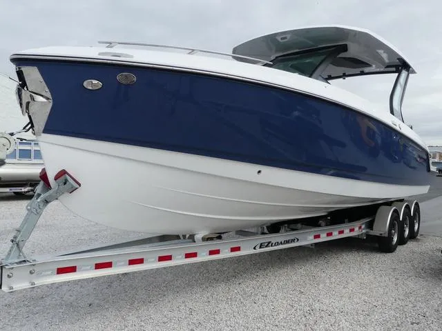 Slide: The Image of 2025 Monterey Elite 30 OB boat on trailer, featuring a sleek blue and white design. - 3