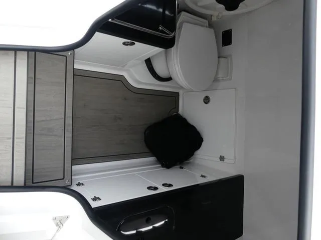 Slide: The Image of Interior of 2025 Monterey Elite 30 OB boat, featuring a compact bathroom area. - 31