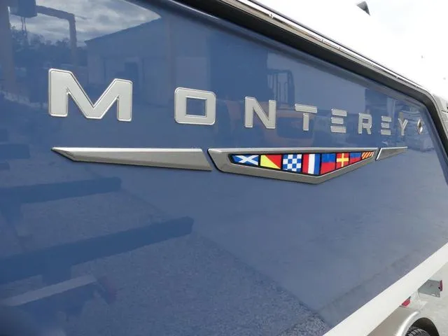 Slide: The Image of 2025 Monterey Elite 30 OB boat with nautical flag design on blue hull. - 4