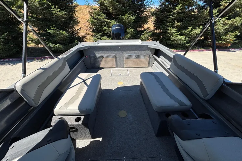 Slide: The Image of Interior of 2025 Spartan 185 Astoria boat with seating and storage, surrounded by trees. - 16