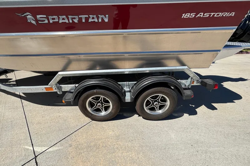 Slide: The Image of 2025 Spartan 185 Astoria boat on trailer, showcasing dual wheels and sleek design. - 40