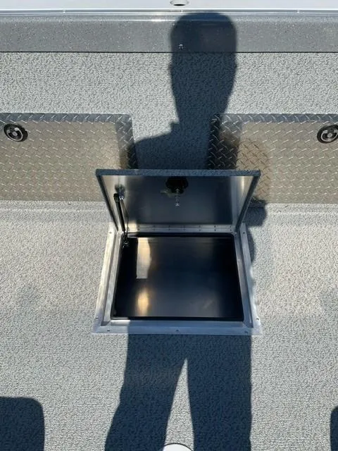 Slide: The Image of 2025 Spartan 185 Astoria boat storage compartment with open hatch, textured flooring, and shadow. - 5