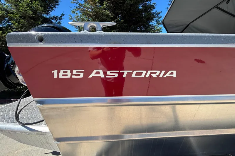 Slide: The Image of 2025 Spartan 185 Astoria boat with red and silver detailing, outdoors. - 10