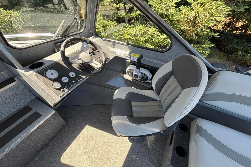 Slide: The Image of Interior of 2025 Spartan 185 Astoria boat, featuring steering wheel and control panel. - 29