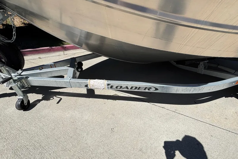 Slide: The Image of Trailer for 2025 Spartan 185 Astoria boat on pavement, featuring sturdy metal frame. - 39