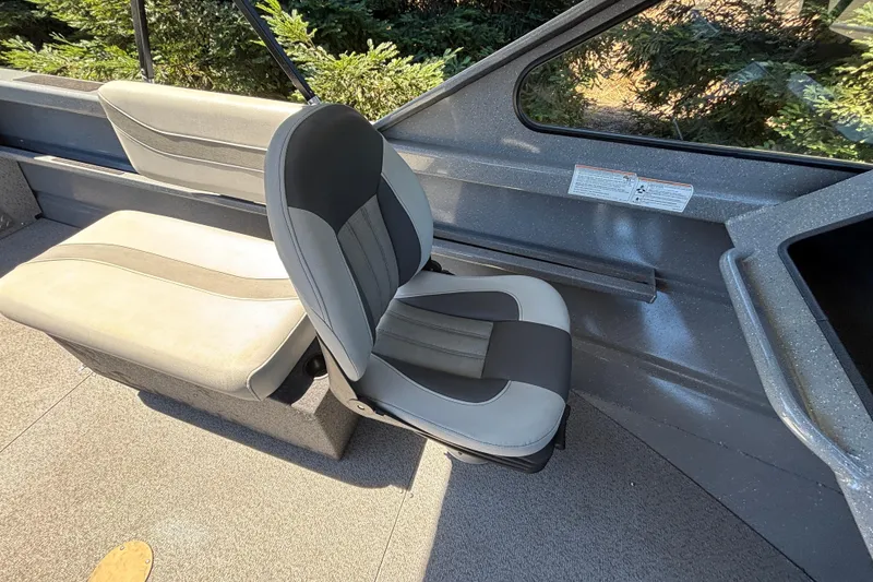 Slide: The Image of Interior seating of 2025 Spartan 185 Astoria boat, featuring gray and black cushioned seats. - 25