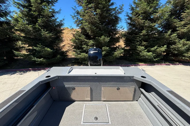 Slide: The Image of 2025 Spartan 185 Astoria boat interior with storage compartments, surrounded by trees. - 24